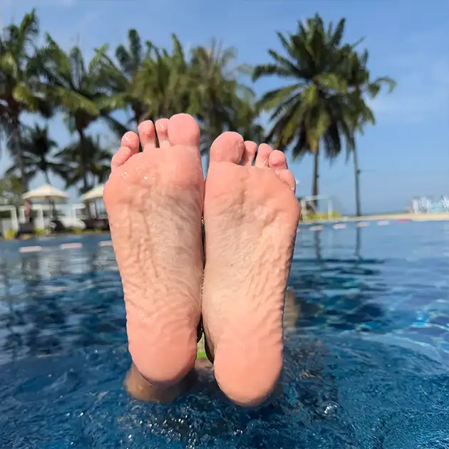 Petite girl in pool with wrinkly feet
